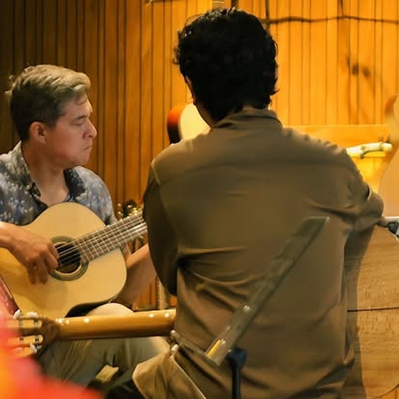 Hai người cùng chơi guitar trong phòng học
